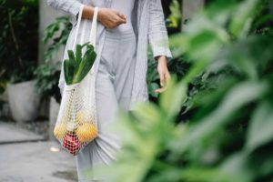 Woman walking with mesh bag filled with produce