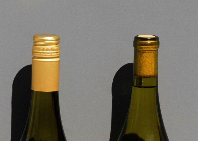 Two bottles of wine. Left is sealed by a screw cap, the other is secured by a cork.