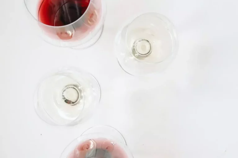 Red and white wine glasses over a white surface
